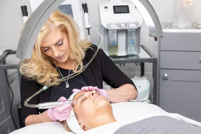 Kathleen giving a client a facial