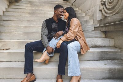 Couple sitting on steps in Philadelphia during candid engagement photo session