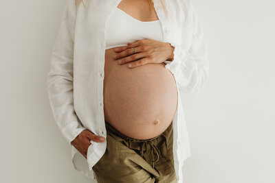 pregnant woman cradling her bare belly