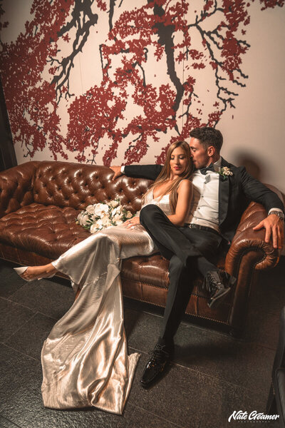 a bride and groom sitting in a leather sofa at Liberty Hotel in Boston
