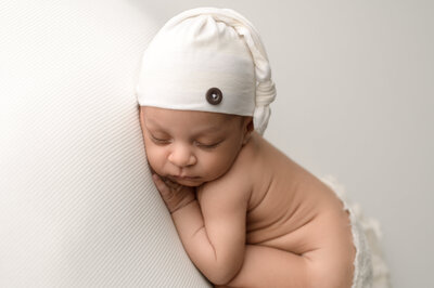 baby boy sleeping with a white hat