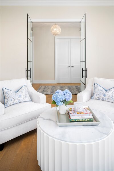 Light and bright sitting area with chairs and flowers