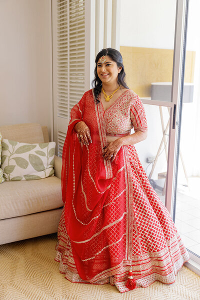 A person in a traditional Indian wedding dress smiling 