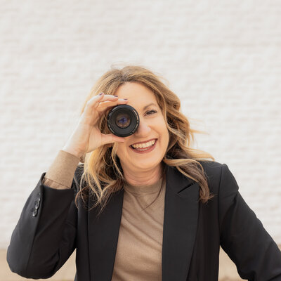 woman laughing with camera wearing black on white background