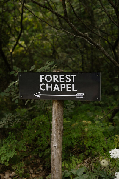 Sign for a forest chapel leading to a durham region elopement led by a wedding officiant