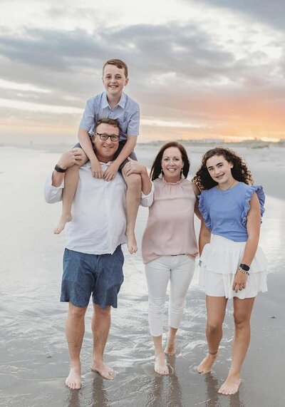 Ms. Jackie, the lead teacher at the Nest, a preschool and learning center in  Surf City, NC family photo featuring her husband and two children