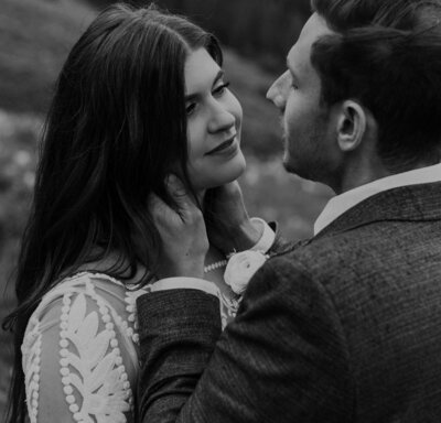 Groom holds bride's face in his hands on their elopement day
