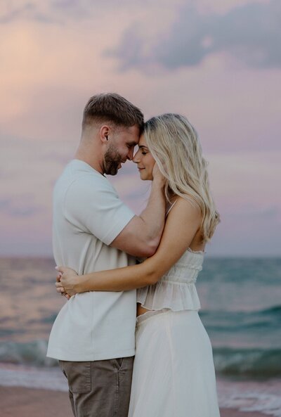 couple embraces on beach in south florida