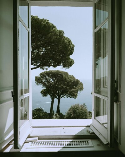 View out of window, over trees and ocean, Amalfi Coast