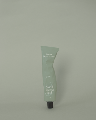 Single sage-green tube labeled ‘Nourish & Revive Mask’ set on a matching background, an example of cohesive beauty brand identity in skincare packaging.