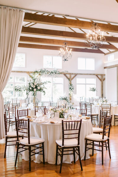 Classic wedding reception centerpiece with roses, peonies, and seasonal flowers, designed by Leigh Florist.