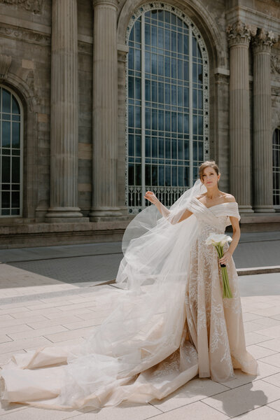 A person in a wedding dress fluffing out their veil 