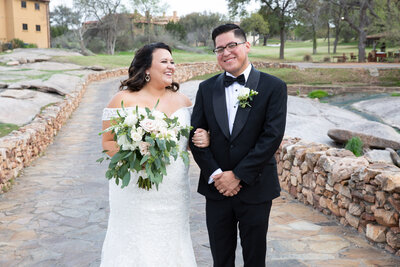 An Austin-based wedding photographer beautifully captures a bride and groom standing on a stone path.