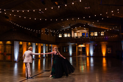 Elegant reception hall with chandeliers and wooden beams at Spruce Mountain Ranch, used as a cover photo for a Colorado Springs best wedding venues blog.