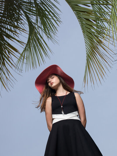 A teenage girl with a large hat on.