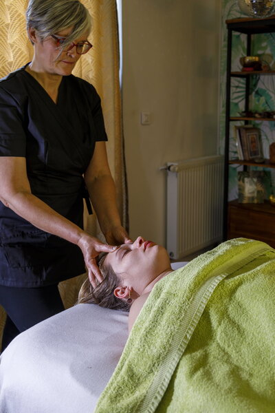 Stéphanie Thiollay massant la tête d'une femme sur la table de massage