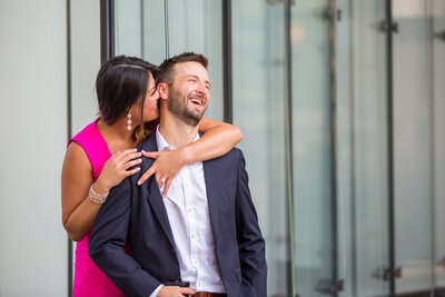 A bride is whispering something to her groom and make him laughing.