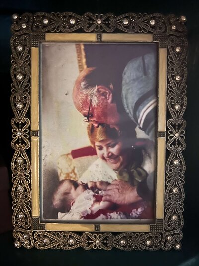 photo of Mariah's grand parents holding her in a vintage frame