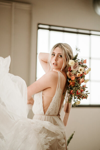 boho bride twirling and holding bouquet