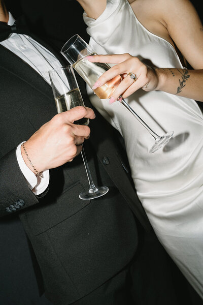 Romantic moment of a couple clinking champagne glasses at their wedding captured by Always Present.