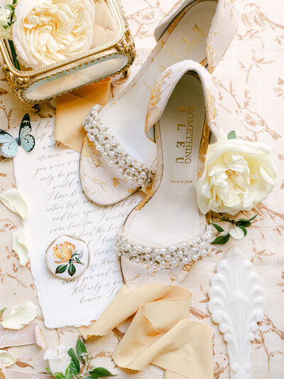 Flatlay Featuring Butterfly, Pearl-Beaded Strap Heels, Yellow Flower, and Handwritten Vows