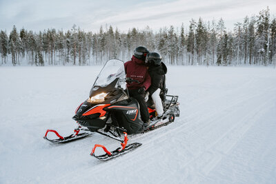 Couple snowmobiling on their wedding day in Akaslompolo Finland