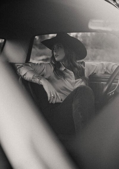 Women wearing a cowboy hat in classic car 