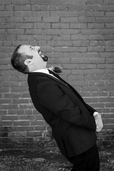 "Groom laughing before first look of his bride in downtown Wilmington"