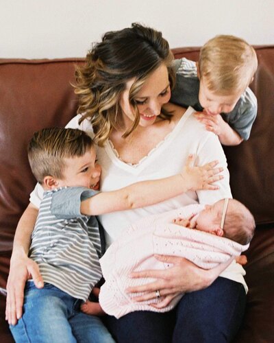 mother snuggling her three children By Carrie Pellerin