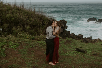 couple kissing next to ocean