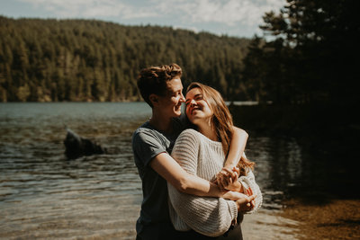 Woman and her fiance embrace and smile at each other during their engagement photography session at Mountain Lake in Orcas Island