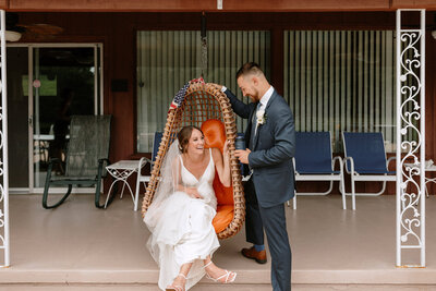 bride and groom laughing in front of a 70's pool house