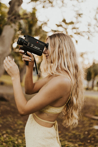 woman wearing a cowgirl hat and holding a camera