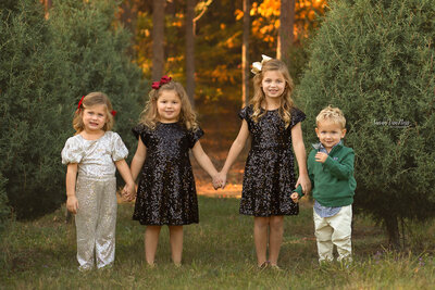 Children holding hands at Christmas Tree Farm by Susan VanNess Photography, a Raleigh children's photographer