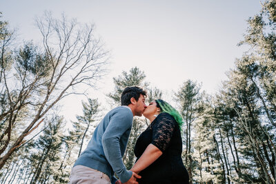 couple kissing in forest engagement session in rhode island