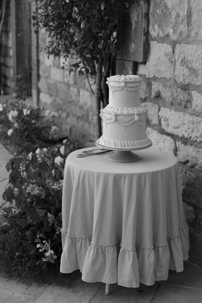 Bride in a v neck wedding dress wearing a top knot standing with floral bouquet