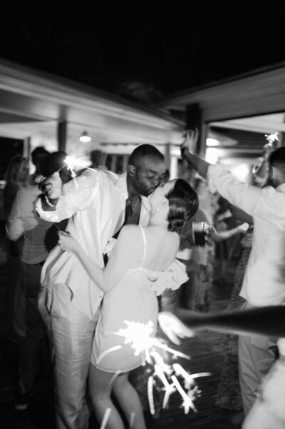 a groom lifts his bride up and her long veil flows