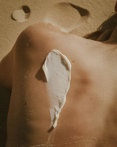 a woman's shoulder with skincare cream on it