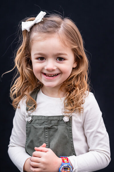 Excited girl with bow clip with sage green jumper | Meg Sivakumar Photography in Woodinville, WA