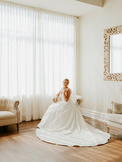 bride sitting in a chair next to a window