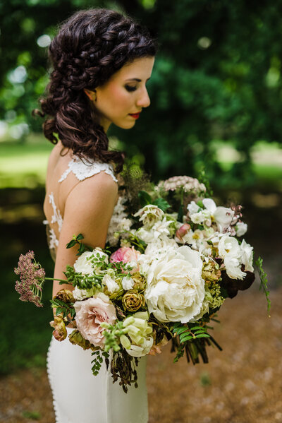 Lush summer bridal bouquet with peony and rose florals in pink, cream, green colors. Summer lush wedding bridal portrait. Design by Rosemary and Finch in Nashville, TN.