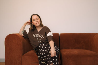 Liv Rollings sitting on a rust colored couch