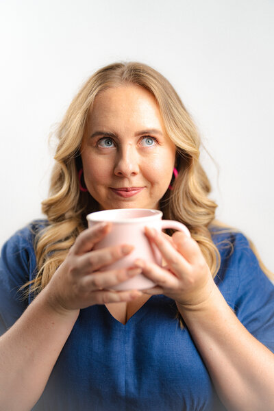 Amy Hart drinking coffee and wearing a blue dress