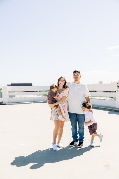 A family snuggles close on a rooftop in Downtown Fresno for their family photos