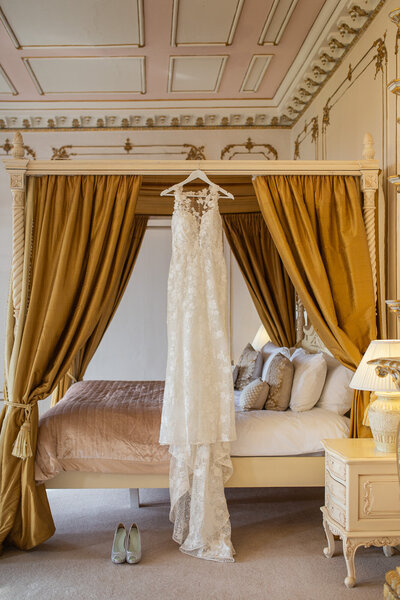 wedding dress hanging up on 4 poster bed