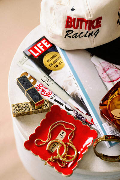 Lauren Loves My Hair - Lifestyle photo of lipstick, jewelry, and magazines on table.