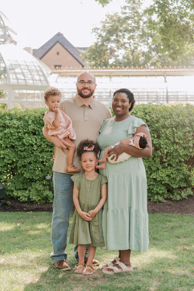 Family of 5 pictured outside of The Frick Greenhouse, the perfect spring backdrop for family photos in Pittsburgh.