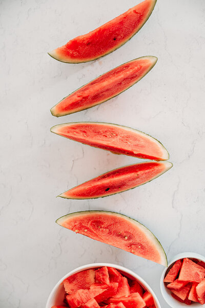 Close-up of vibrant watermelon arranged on a white background, representing creativity and writing tools.