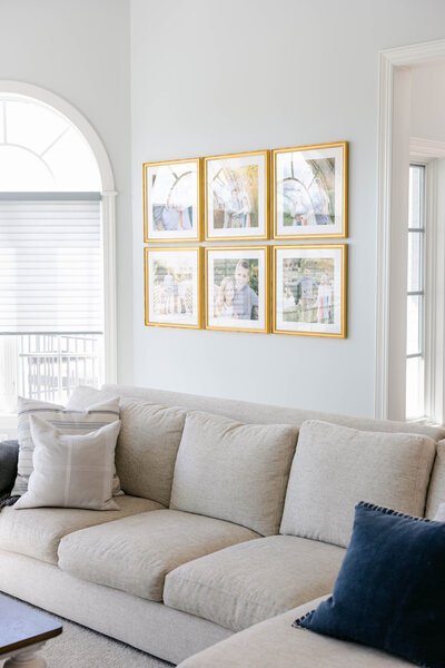framed gallery of family photos hanging above a couch