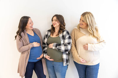 Three pregnant women smiling